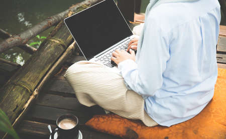 Young asia muslim woman work out office chill on green nature park concept for female entrepreneur job on chic workplace, financial freedom, mature student use internet in university college for meet.の写真素材