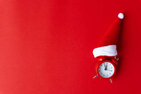 Creative flat lay vintage clock on red office table top view background concept alarm clock on red paper color with copy space in minimal style, empty template for text, break workplace at noon for lunch, back to school.の写真素材