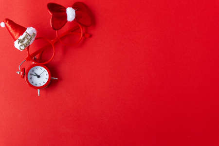 Creative flat lay vintage clock on red office table top view background concept alarm clock on red paper color with copy space in minimal style, empty template for text, break workplace at noon for lunch, back to school.の写真素材