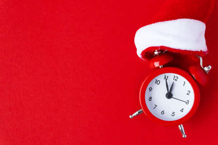 Creative flat lay vintage clock on red office table top view background concept alarm clock on red paper color with copy space in minimal style, empty template for text, break workplace at noon for lunch, back to school.の写真素材