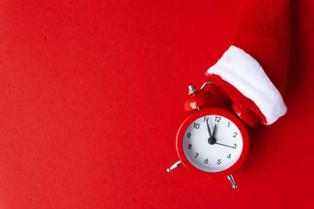 Creative flat lay vintage clock on red office table top view background concept alarm clock on red paper color with copy space in minimal style, empty template for text, break workplace at noon for lunch, back to school.の写真素材