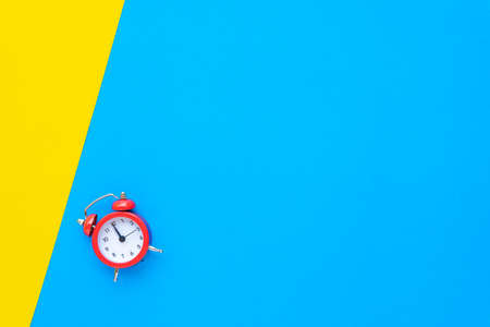 Abstract creative flat lay vintage yellow blue table top view office background concept red clock on paper color in minimal style, Hot summer holiday time to break workplace at noon for lunch, Retro Hipster back to school vacationの写真素材