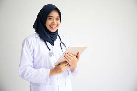Young Arab Muslim intern doctor women smile on isolate white background concept for Islam people working in medical hospital health care, Modern Nurse wearing hijab in medico clinic business service.の写真素材