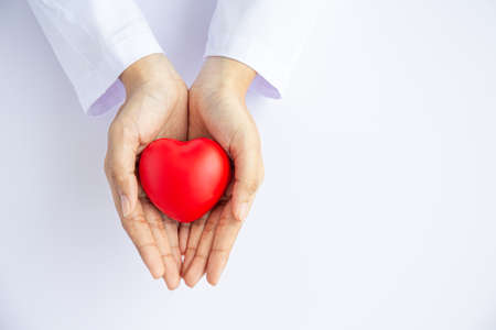Woman doctor hands holding red heart on white background donate for hospital care concept. world heart day and world health day, CSR community, foster support patient.の写真素材