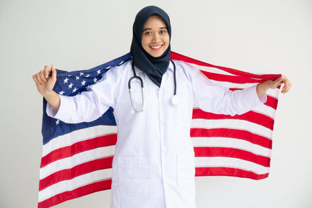 Young Muslim women exchange Students scholarship wear holding america flag over white background...