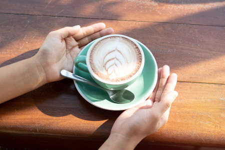 One coffee cup of hot black cappuccino on clean wooden table top view in warm morning light. Hot espresso in ceramics mug on empty rustic brown wood color concept for Aroma love caffeine taste smell.の写真素材
