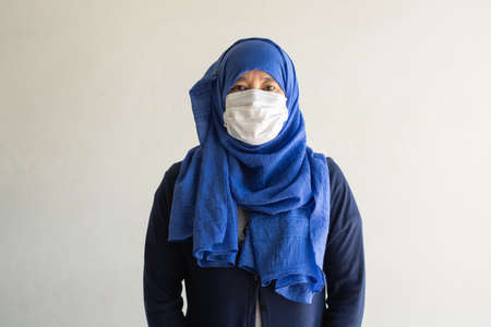 Asian woman in medical mask Coronavirus pandemic disease isolate background. COVID-19 virus from Malaysia epidemic outbreak to global, Indonesia concept for person social distance, Respiratory illnessの写真素材