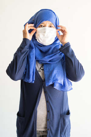 Asian woman in medical mask Coronavirus pandemic disease isolate background. COVID-19 virus from Malaysia epidemic outbreak to global, Indonesia concept for person social distance, Respiratory illnessの写真素材