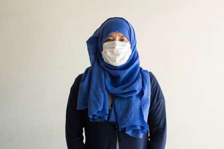Asian woman in medical mask Coronavirus pandemic disease isolate background. COVID-19 virus from Malaysia epidemic outbreak to global, Indonesia concept for person social distance, Respiratory illnessの写真素材