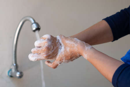 Muslim women wash hand with soap alcohol gel for sanitizer in kitchen sink concept for prevent Hygiene health care. Quarantine Islam people spread of germs and microbe bacteria outbreak coronavirus 19の写真素材