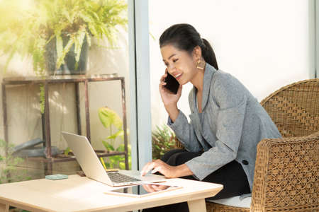 Young student woman use wireless internet learning and co-working at home on mobile tablet app. Modern girl people blogger couch on laptop education classroom online device, Social distancing in spaceの写真素材