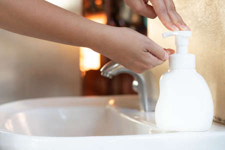 Asian Mom women wash her kid hand with soap alcohol gel for sanitizer in kitchen sink concept for prevent Hygiene health care. Quarantine child people spread of germs and microbe bacteria outbreak coronavirus 19の写真素材