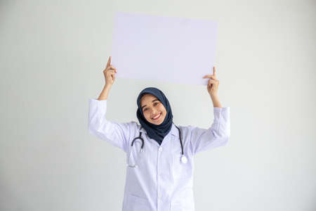 Young Arab Muslim doctor women smile showing on isolate card white background concept for Islam people working in medical hospital health care, Modern Nurse wear hijab in pandemic business service.の写真素材