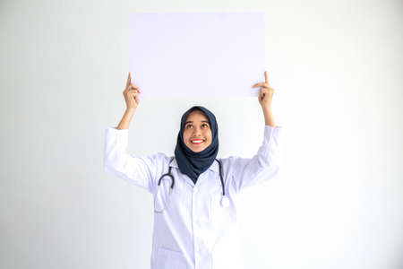 Young Arab Muslim doctor women smile showing on isolate card white background concept for Islam people working in medical hospital health care, Modern Nurse wear hijab in pandemic business service.の写真素材