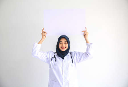 Young Arab Muslim doctor women smile showing on isolate card white background concept for Islam people working in medical hospital health care, Modern Nurse wear hijab in pandemic business service.の写真素材