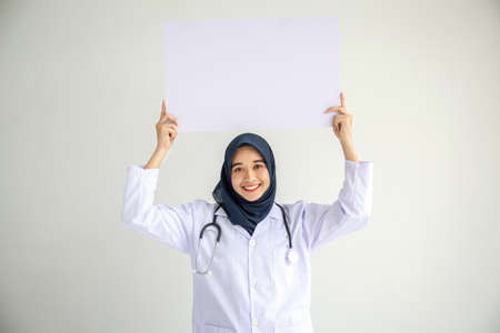 Young Arab Muslim doctor women smile showing on isolate card white background concept for Islam people working in medical hospital health care, Modern Nurse wear hijab in pandemic business service.の写真素材