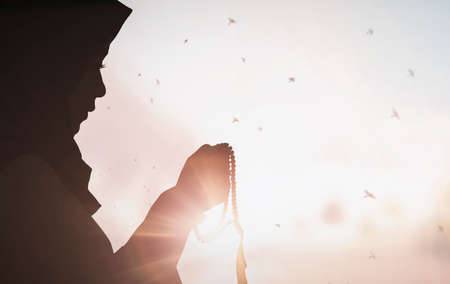 Young female muslim prayer with hijab praying to God front of white background concept for eid mubarak, life and soul fasting of international islamic ramadan, Namaz.の写真素材