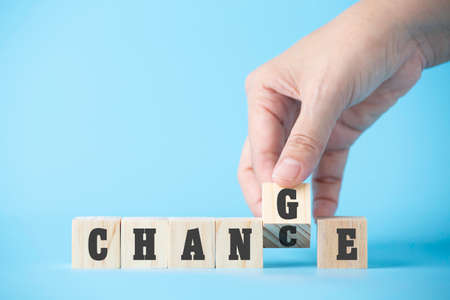Woman hand hold wooden cube word on business blue background concept for change mindset to building organisation growth in success, chance of solution strategy opportunity, creative innovation managementの写真素材