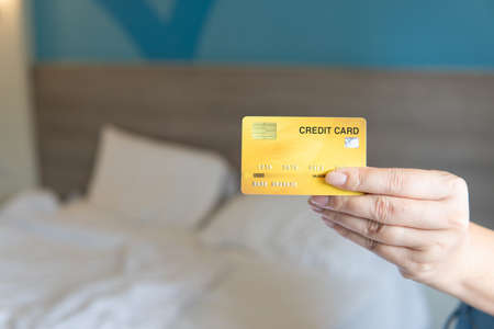 Business woman hand hold credit card to shopping internet online bill on computer, Debit saving purchase buy on table background. Shopaholic people retail pay sale money, bank terminal account conceptの写真素材