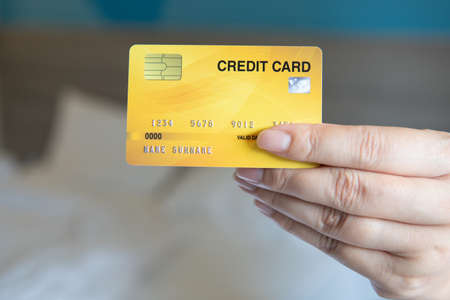 Business woman hand hold credit card to shopping internet online bill on computer, Debit saving purchase buy on table background. Shopaholic people retail pay sale money, bank terminal account conceptの写真素材