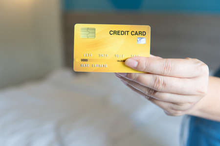 Business woman hand hold credit card to shopping internet online bill on computer, Debit saving purchase buy on table background. Shopaholic people retail pay sale money, bank terminal account conceptの写真素材