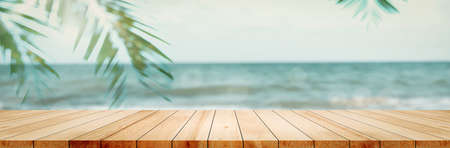 Panoramic empty clean wood counter table top blur shinny white bokeh light on summer beach background for product morning scene display montage, Abstract Blurry wooden desk in vacation trip backdrop.の写真素材