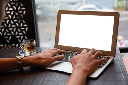 Young entrepreneur SME use notebook showing blank screen with clipping path display  in cafe concept.Â Hand of business man hold smartphone People use 5G cellular work app with modern internet of thingsの写真素材