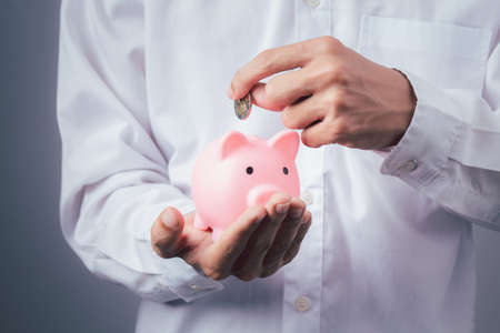 Hand of kid holding coin put in piggy bank with money stack growing growth saving money, Concept invesment for financial freedom plan, business deposit to hope successの写真素材