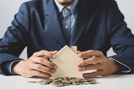 Hand of Business man holding coin put in piggy bank with money stack growing growth saving money, Concept invesment for financial freedom plan, business deposit to hope successの写真素材