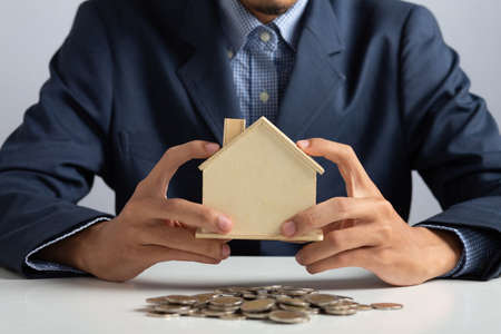 Hand of Business man holding coin put in piggy bank with money stack growing growth saving money, Concept invesment for financial freedom plan, business deposit to hope successの写真素材