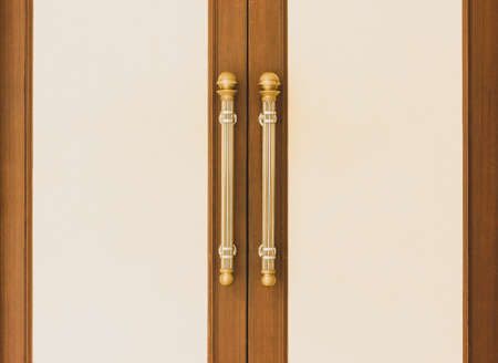 Vintage gold door handle front side of entrance interior home. Close-up closed light wooden doors in style in the interior. Doorways fittings for hotel indoor design. House apartment entrywayの写真素材