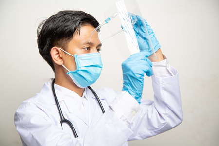 Doctor Man on blur hospital laboratory panoramic blue background. COVID-19 virus epidemic outbreak to Coronavirus pandemic disease global recession wide concept for social scientist vaccineの写真素材