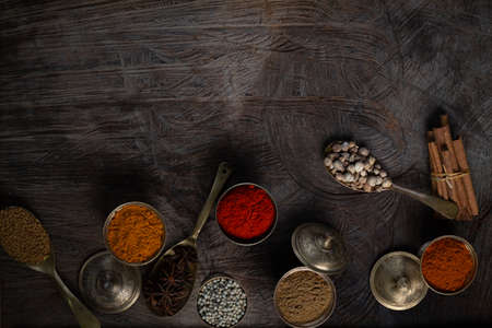 Condiment of indian food Spice garnish background on wood table top view. Seasoning of Asian organic herb cuisine flavour in kitchen board, chilli spicy taste conceptの写真素材