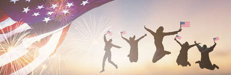 Silhouettes group of people holding the Flag of the USA jump in America celebrate 4th of July fireworks.  Waving happy American Flags at Sunset. Crowd celebrating Independence Day.の写真素材