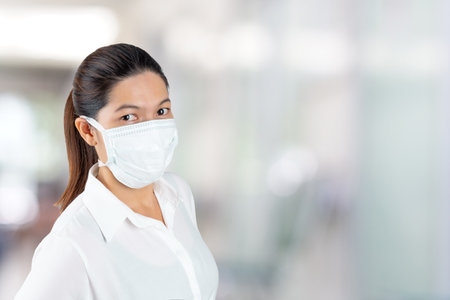 Young woman in safety medical mask in home isolation on blur outside office window view self business quarantine concept virus pandemic, house quarantine.の写真素材