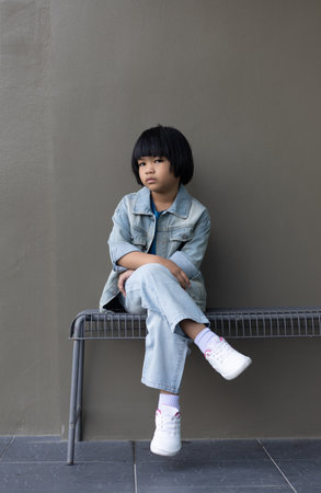 Girl child wearing blue jeans costume standing with her friend on in studio. A sad Girl looking away on grey wall background in family parents house 
Back to school 5 years old children Happy to learnの写真素材