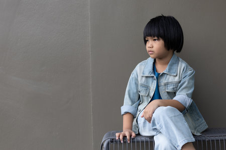 Girl child wearing blue jeans costume standing with her friend on in studio. A sad Girl looking away on grey wall background in family parents house 
Back to school 5 years old children Happy to learnの写真素材