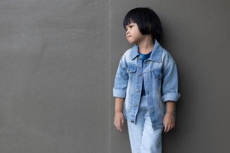 Girl child wearing blue jeans costume standing with her friend on in studio. A sad Girl looking away on grey wall background in family parents house 
Back to school 5 years old children Happy to learnの写真素材