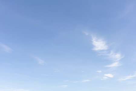 The clear blue sky with white clouds provides a bright and sunny background, enhancing the natural beauty of the landscape on this pleasant summer dayの写真素材