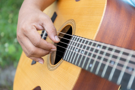 Christian guitar player strums with passion, their fingers crafting a soulful melody as the gathering joins in worship, praising God with every note and heartfelt song.の写真素材