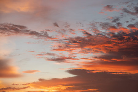 Dramatic sunset sky with vivid orange and purple clouds, creating a peaceful and romantic...