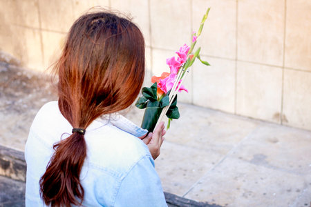 Thai girl praying in Buddhist temple, holding flowersの写真素材