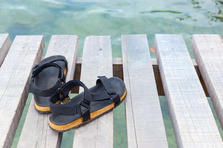 Travel concept with footwear over wooden  in front of sea landscapeの写真素材