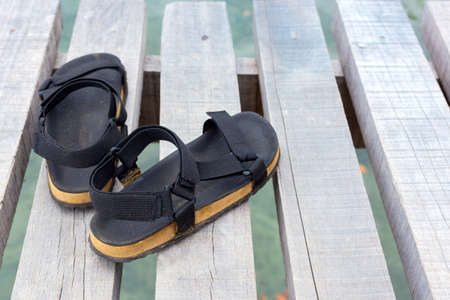 Travel concept with footwear over wooden  in front of sea landscapeの写真素材
