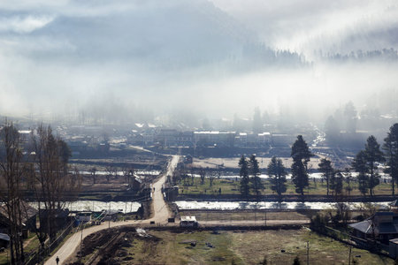 Panoramic view of beautiful mountain landscape small village among snow pine trees mountain backgroundの写真素材