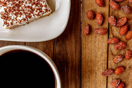 Delicious breakfast an invigorating cup of black coffee, cheesecake and almonds in honeyの写真素材