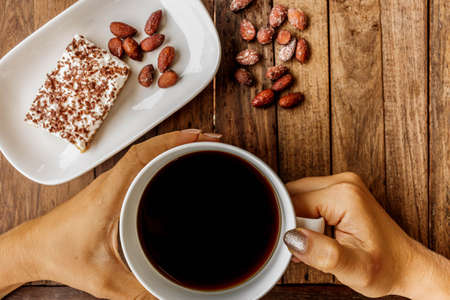 girl drinking strong coffee while sitting in the cafe at the wooden tableの写真素材