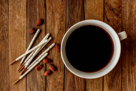 strong coffee on a wooden table and delicious snacksの写真素材