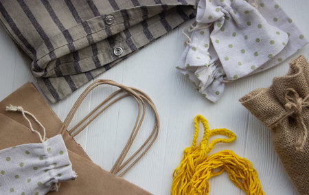 Reusable and paper bags for shopping in the store on a light wooden background. Zero waste concep