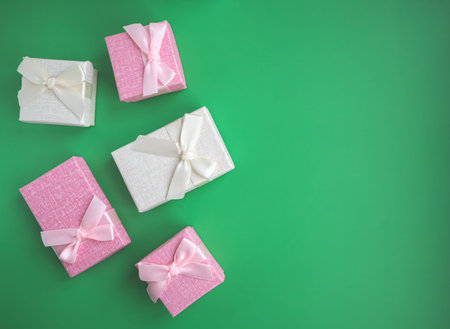 Boxes for small presents and gifts in pastel colors on a light green background with space for text....